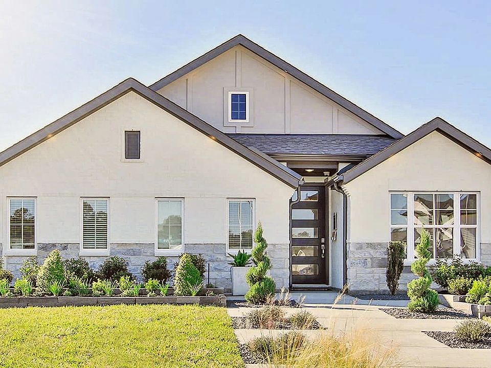 Elegant Cypress Green home features sleek stone accents and expansive windows, offering a refined li