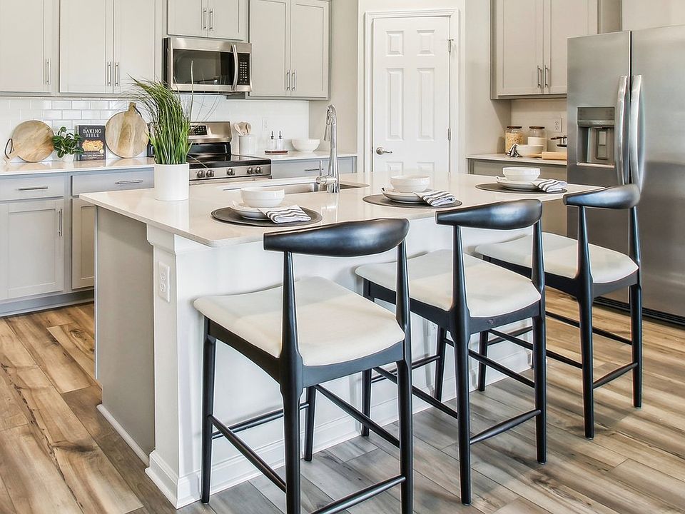 Experience luxury with sleek cabinetry, stainless steel appliances, and elegant island seating in Su
