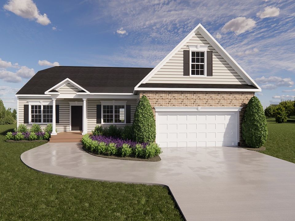 House at Lot 57 with a front porch, wide driveway, and lush greenery under Patrick Henry Heights blu