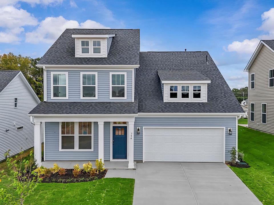 New two story home with two car garage, large windows, and light colored exterior siding